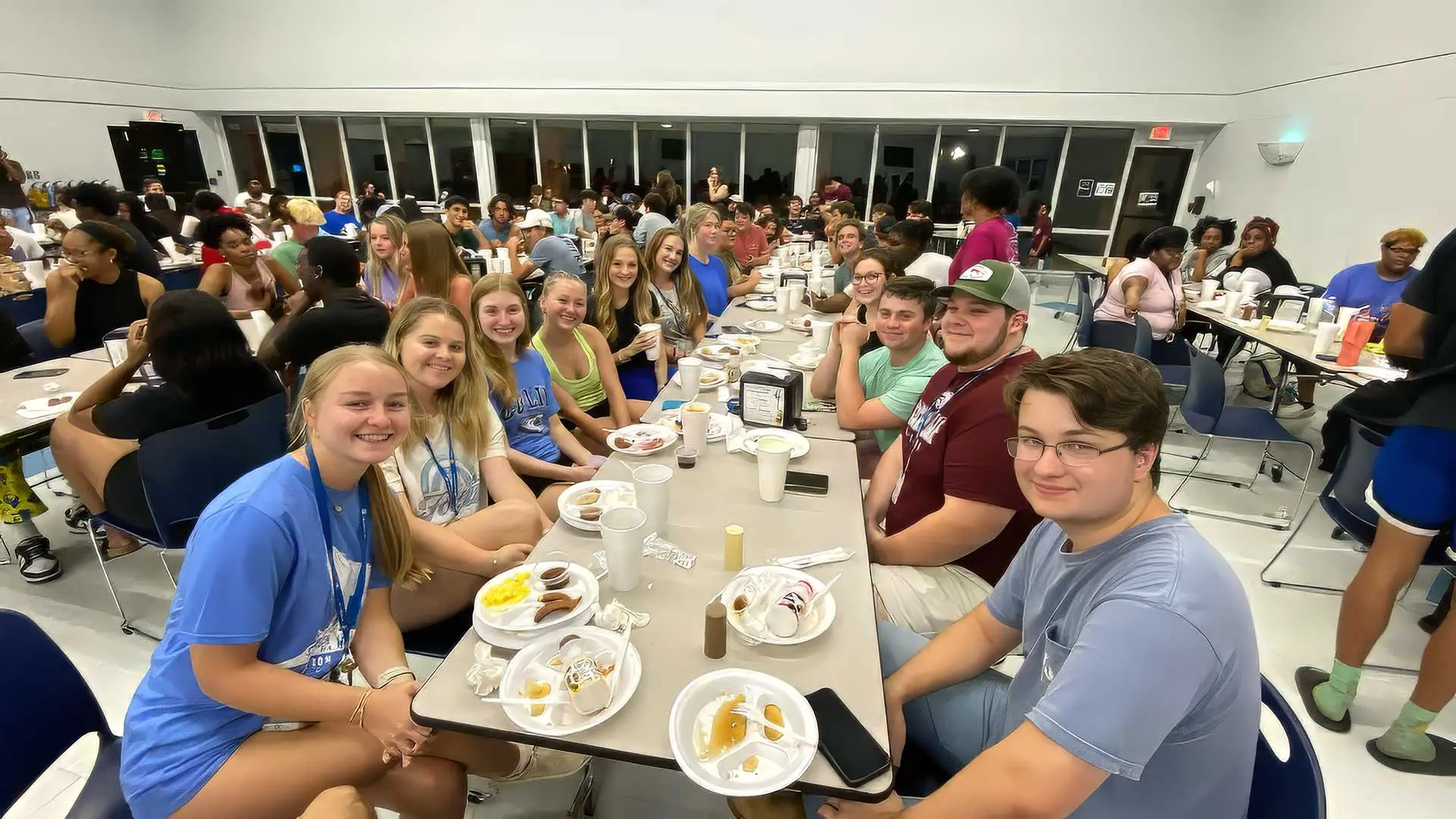 Students sitting in cafeteria smiling